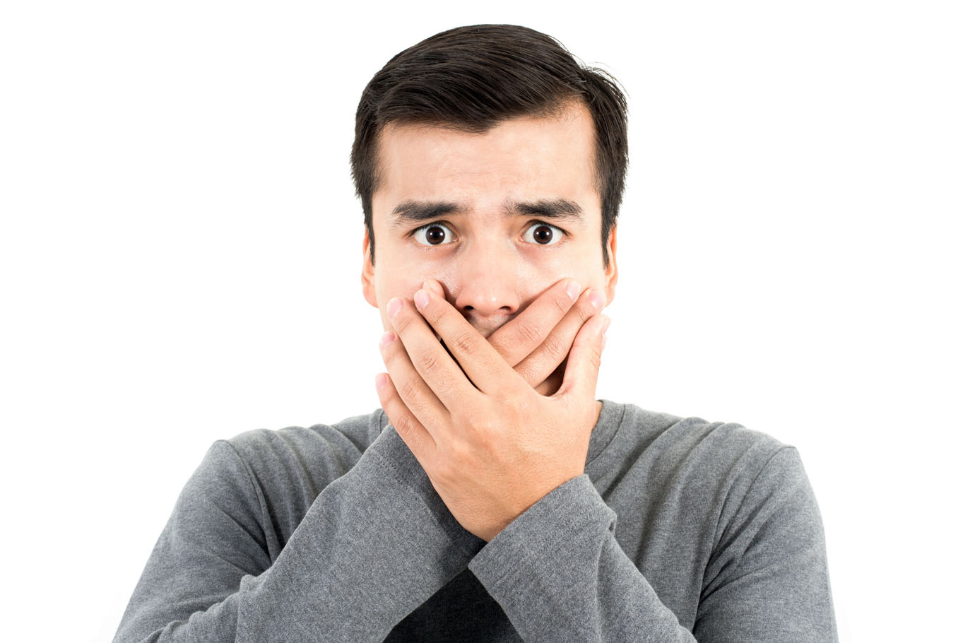 A man covering his mouth with both hands and looking worried