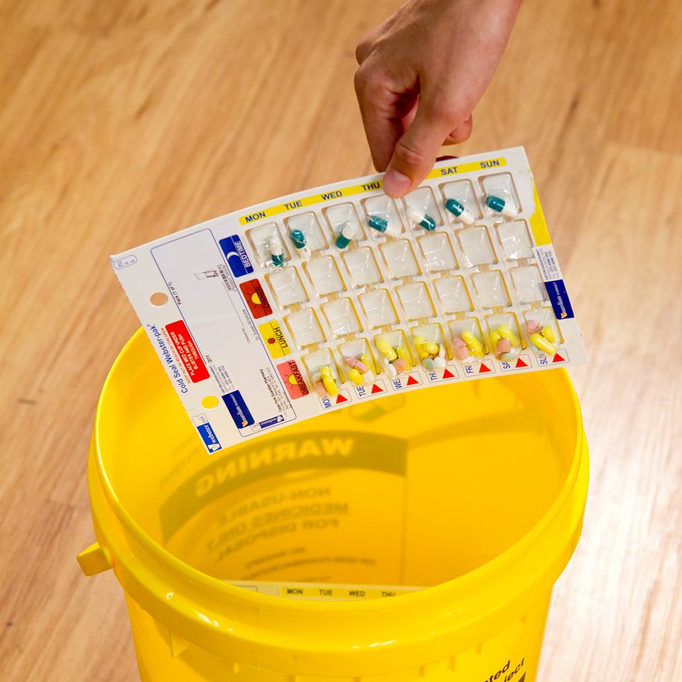 Unwanted medicine being placed in yellow container