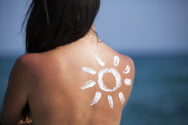 Back of woman with a sun drawn on her with sunscreen
