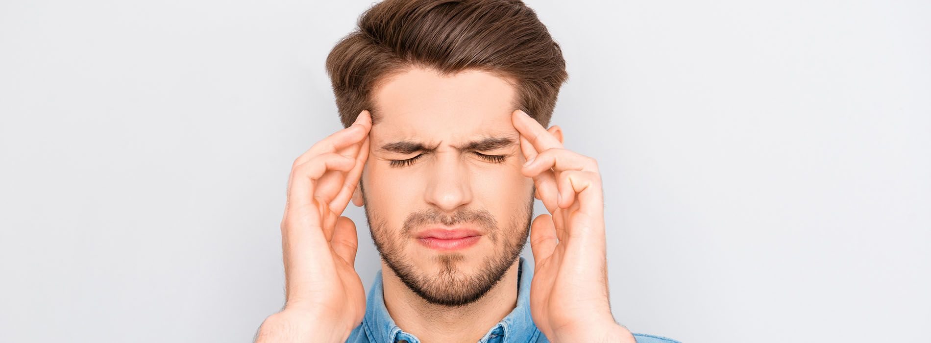 Man hold his hand on either side of his head looking stressed