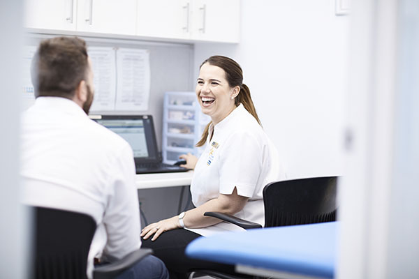 Smiling Pharmacist speaking with a customer